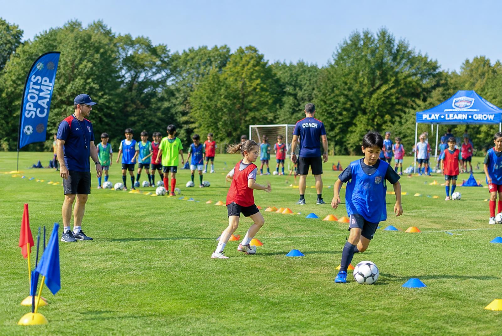 Campers rotating through drill stations with coaches on the field